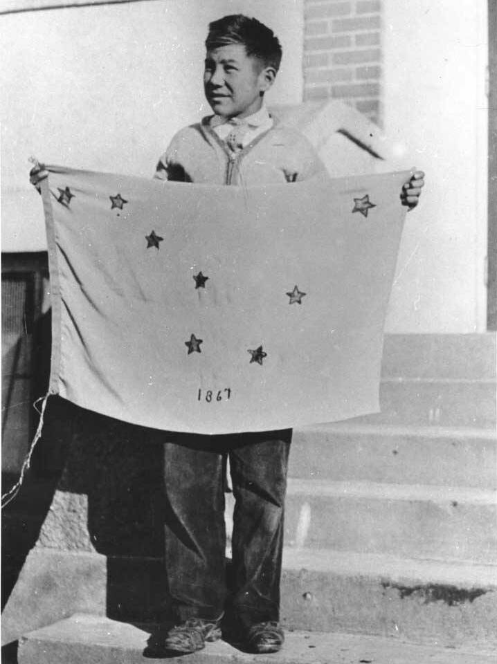 Benny Benson holding the flag of Alaska that he designed